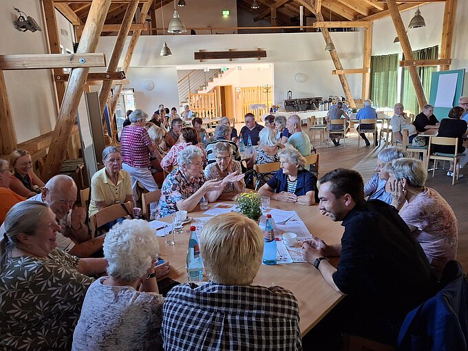Menschen an Tischen in der Diskussion